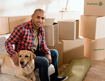 african american man with labrador dog in new apartment with cardboard boxes